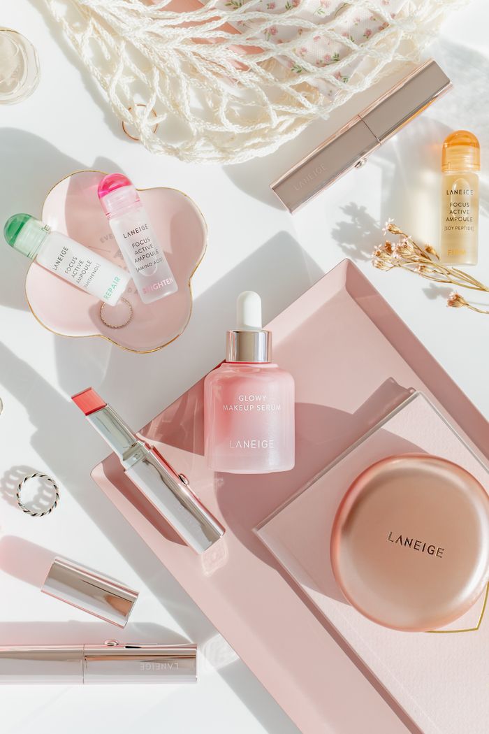 Stylish flat lay of Laneige skincare and makeup items on a pastel surface.
